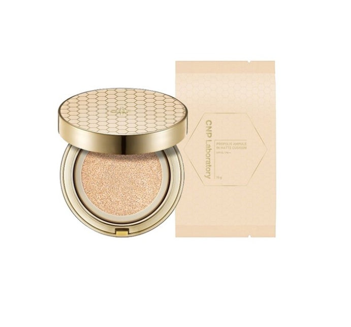 A compact pan with a beige matte finish, adorned with a honeycomb pattern, and its cap is also beige with a golden rim. The product is labeled with 'CNP LABORATORY Propolis Ampule' and has the SPF and PA+++ rating indicated.